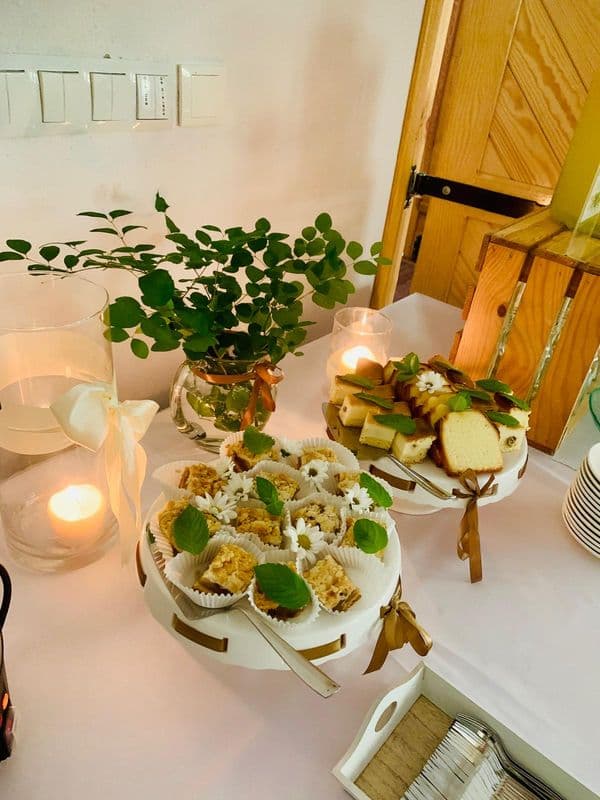 na białym obrusie, przy świecach ciasta na eleganckich talerzach,