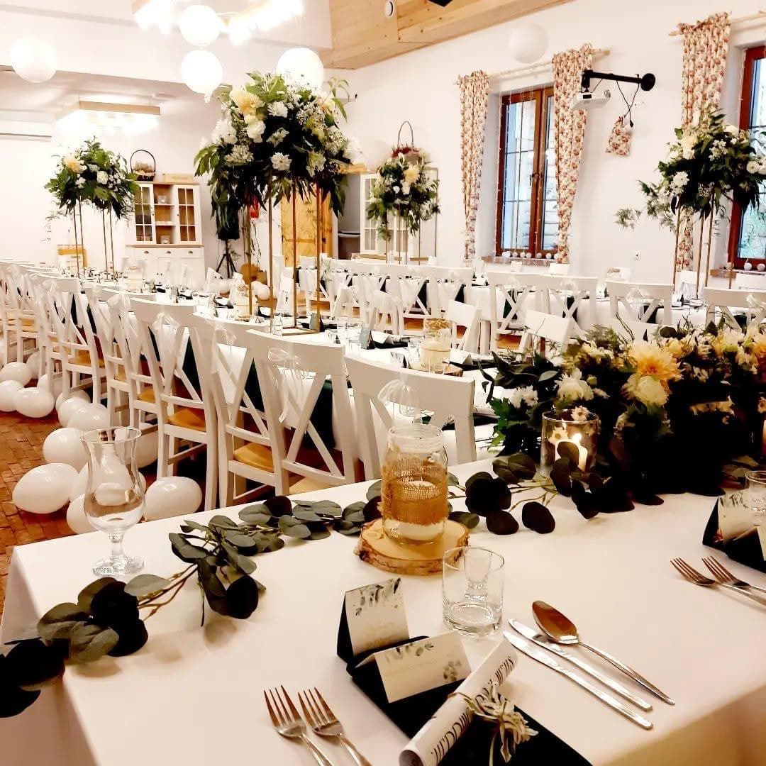 sala z dwoma elegancko zastawionymi stołami