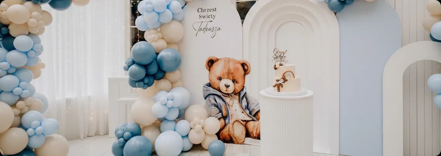 niebieskie i białe balony, obok miś, tort i podpis "Chrzest Święty'